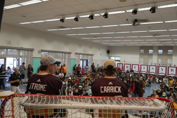 Ducks players on stage looking at students