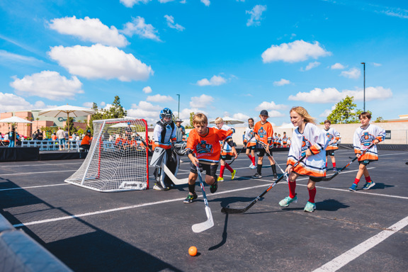 Street hockey players chase after ball