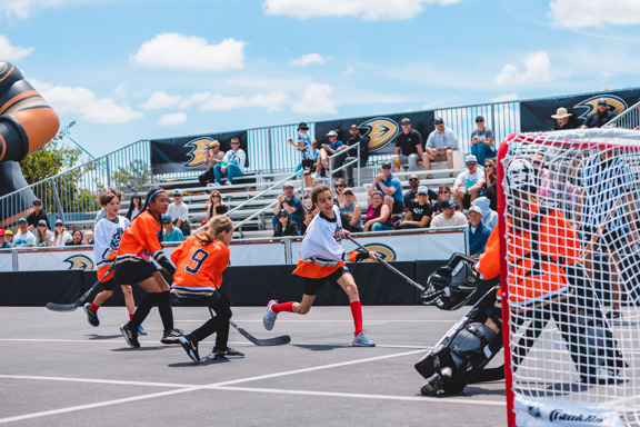 Female street hockey player shooting on net