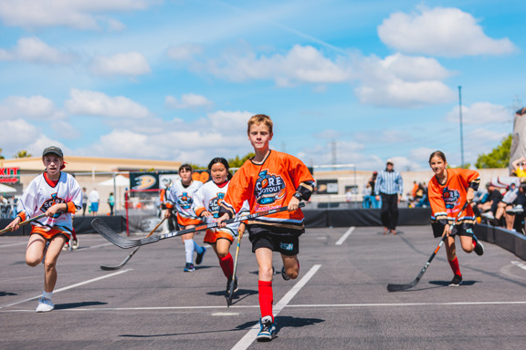 Street hockey players running with hockey sticks