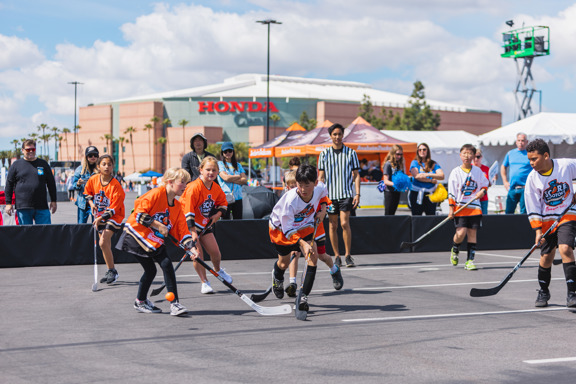 Street hockey players battle for position 